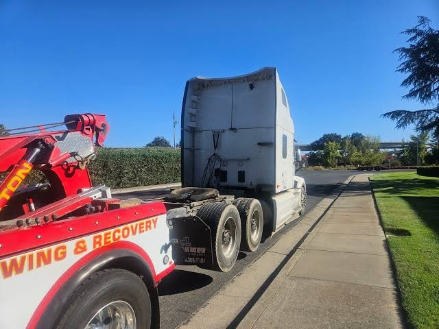 Commercial truck being towed on a highway